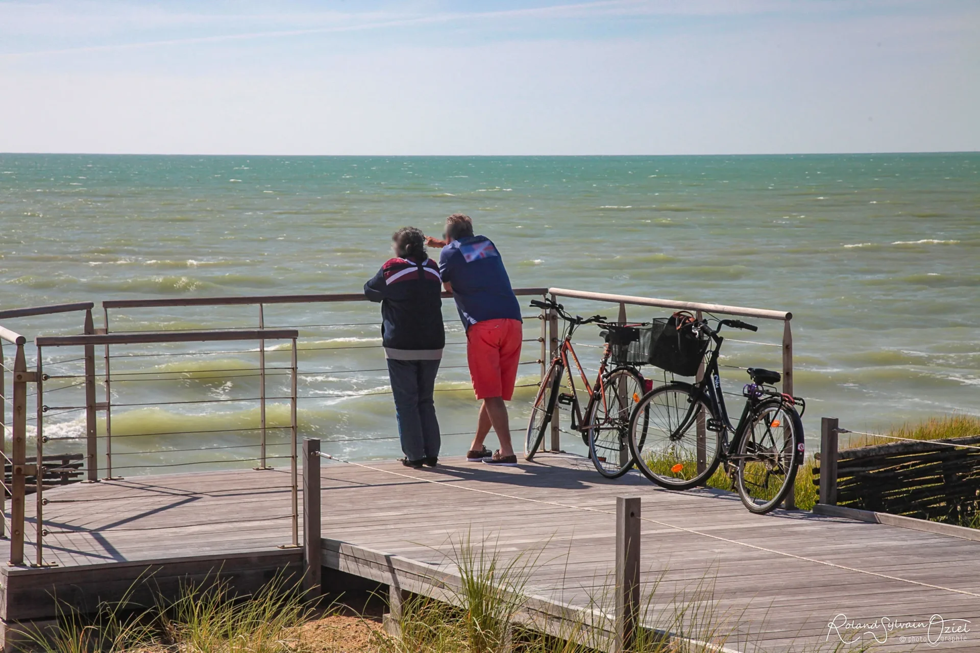 Belvédère en bois face à l’océan avec vélos et promeneurs en Vendée
