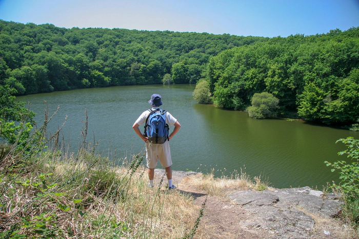 Un randonneur face au lac et à la forêt qu'il vien de parcourir
